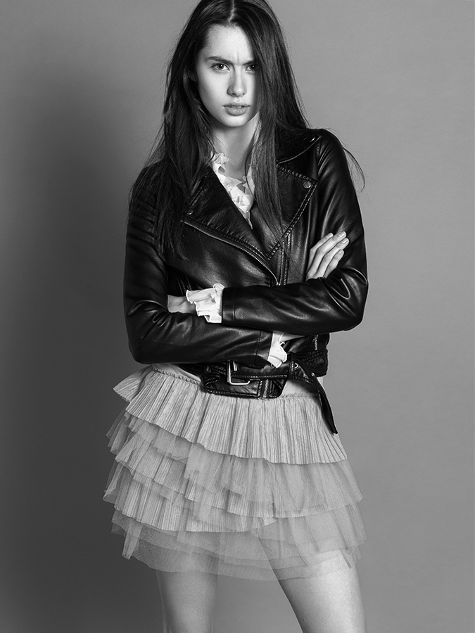 Model Anne Richey striking a pose in black leather jacket and beige tutu photographed in black and white by Joshua Pyles