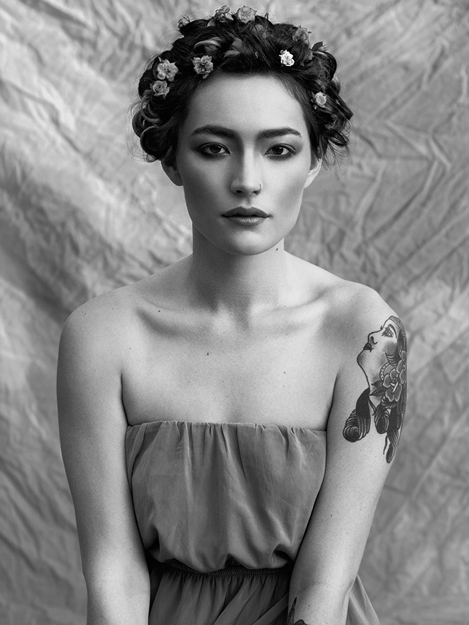 Portrait of beautiful asian woman Correen Bo with smoky makeup, flowers in her tightly ringletted hair and shoulderless dress photographed in black and white by Joshua Pyles