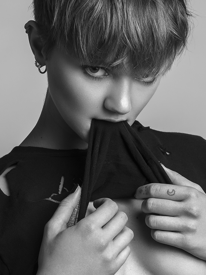 Fashion image of supermodel Peyton Knight lifting her t-shirt above her breasts and holding it in her mouth, photgraphed in black and white by Joshua Pyles