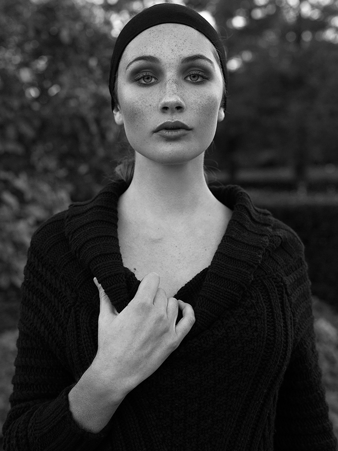 Model Sienna Feher in smoky makeup with thick black headband and  black heavy knit sweater photographed in black and white by Joshua Pyles